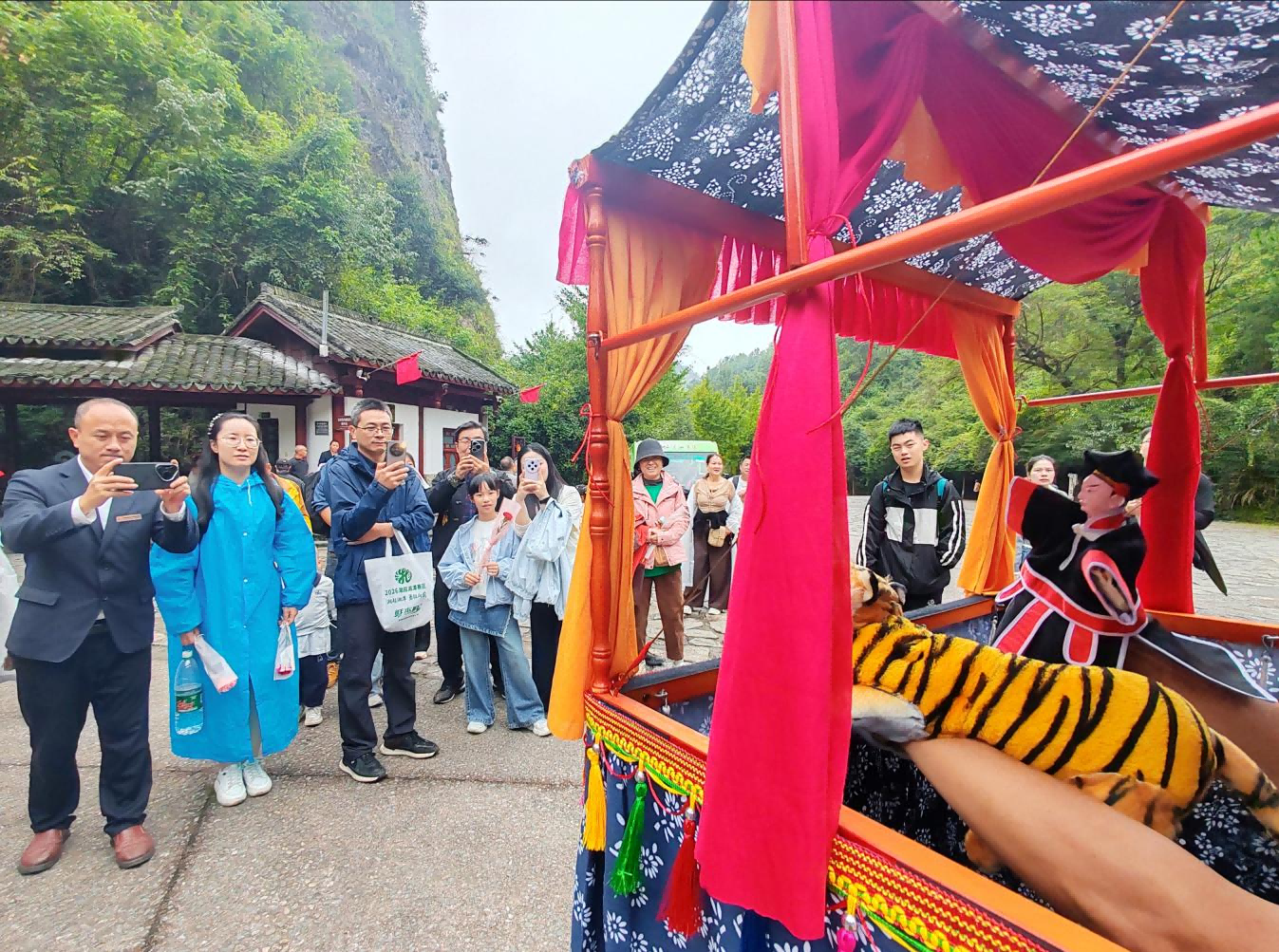 游客驻足欣赏国家级非遗邵阳布袋戏展演（鄢跃斌/摄）